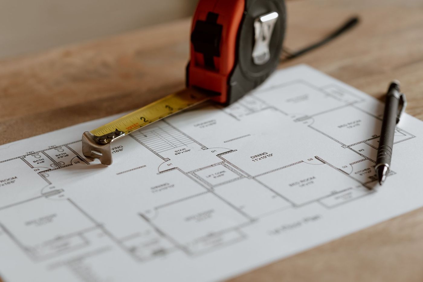 Plans, a tape measure and a pencil on a worktable